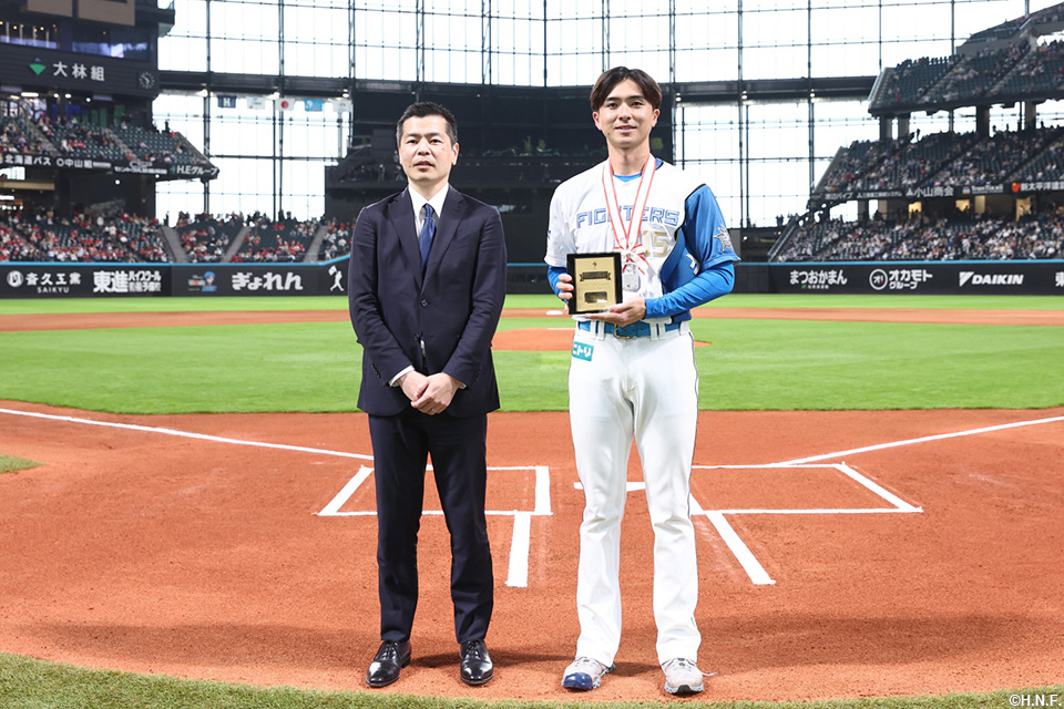 試合前、1000投球回達成の連盟表彰を受ける上沢投手