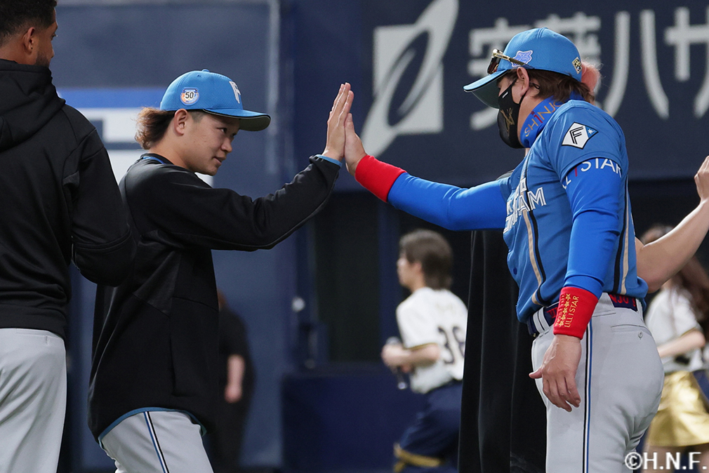 新庄監督とハイタッチをする鈴木投手"