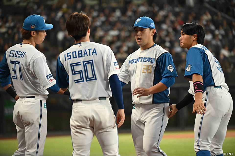 9回表、マウンドを降りる河野投手と迎える野手陣