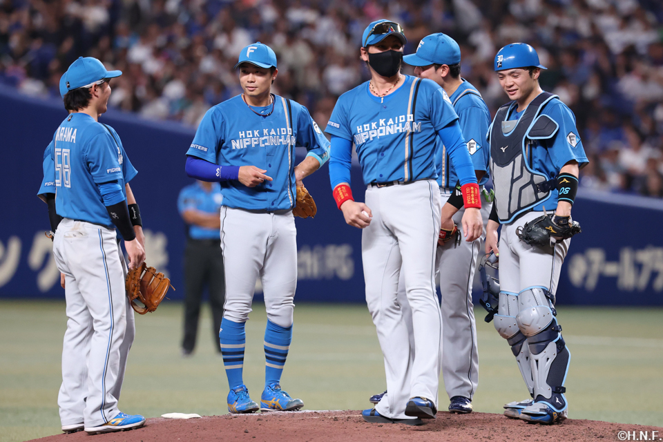 8回裏、マウンドに集まる選手たちと新庄監督