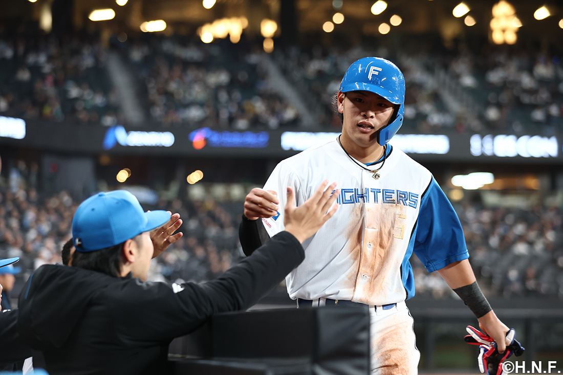 ベンチにいるメンバーとタッチをする野村選手