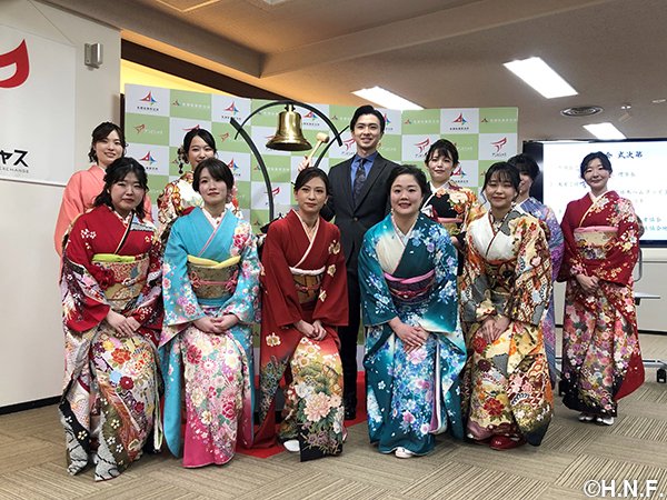 札証の鐘を鳴らす上沢直之投手と晴れ着姿の女性職員たち