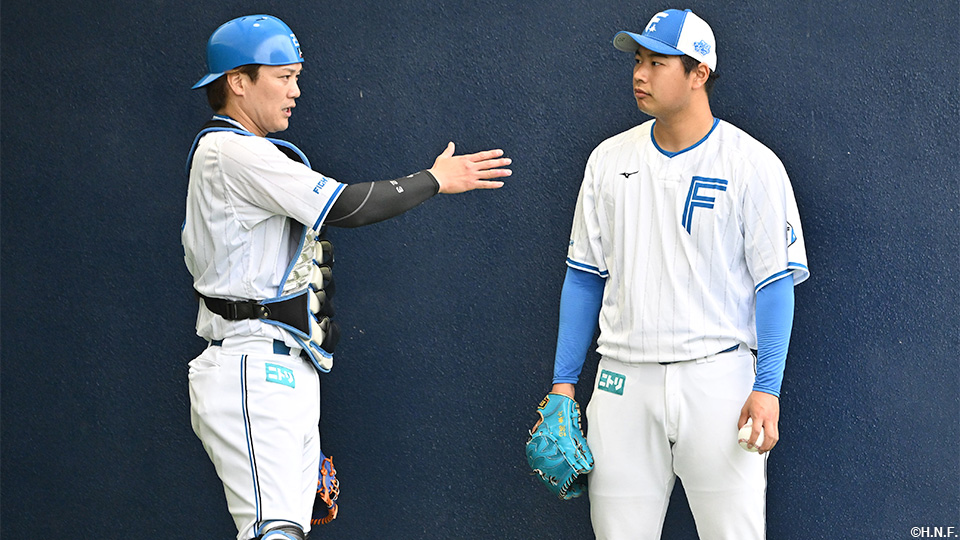 会話をする伏見選手、松浦投手